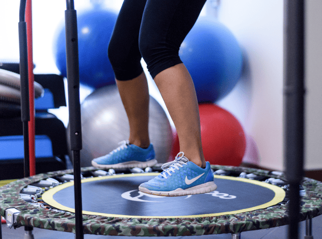 ragazza in tenuta sportiva salta su un trampolino in palestra